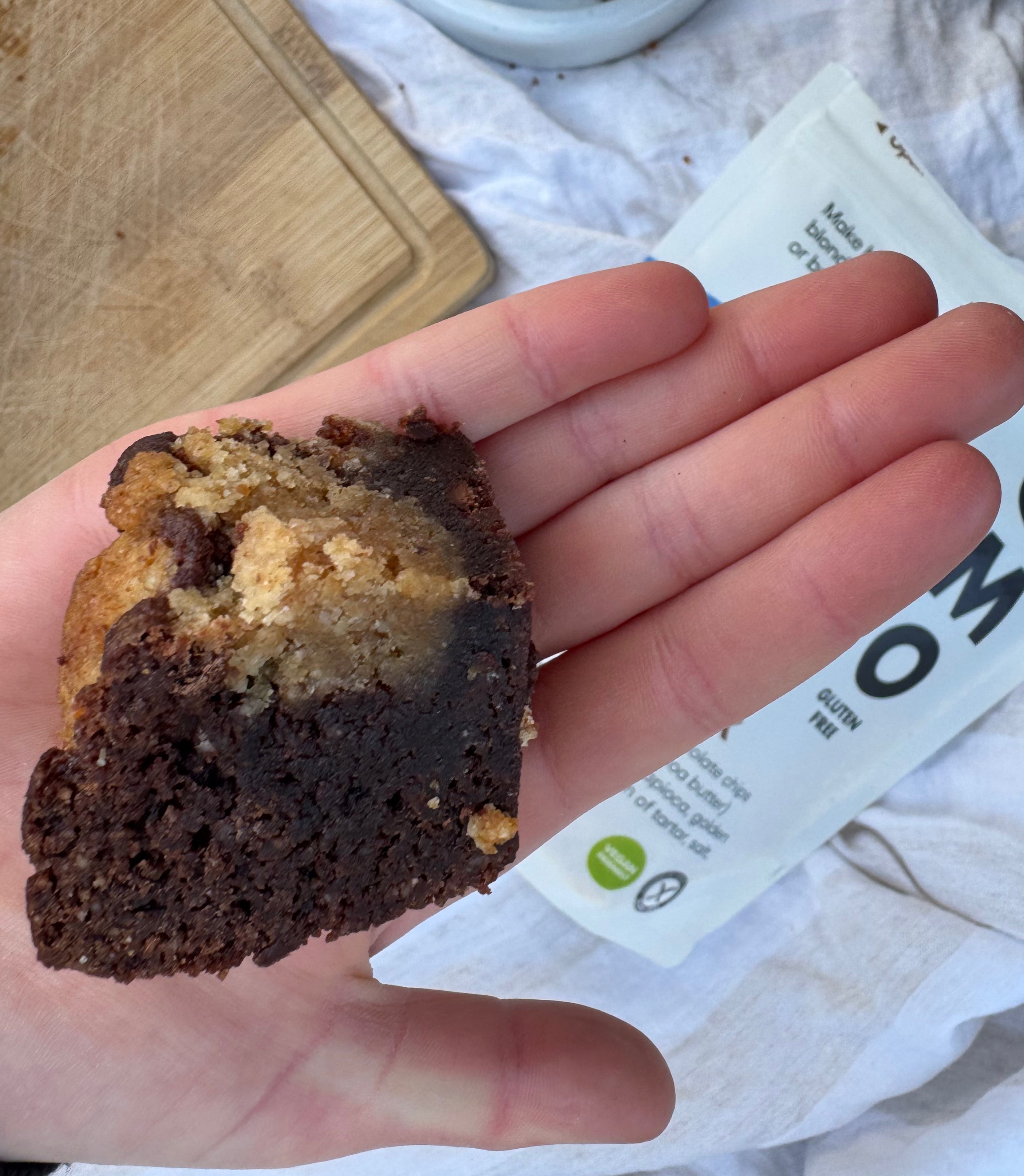 Hand holding gluten free brookie made with YOMO gluten free choc chip mix, gluten free brownie, gluten free choc chip cookie, vegan brookie