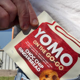 YOMO gluten free Choc Chip Gingerbread cookie package can fit in your pocket - cookie pictured going into a skirt pocket