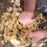 Child's hands mixing choc chip cookie dough, gluten free baking with kids, best gluten free choc chip cookies, YOMO gluten free choc chip mix in action